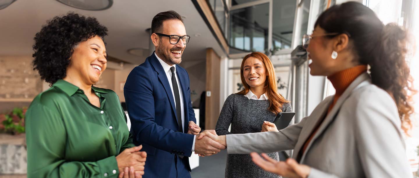 smiling business people and shaking hands