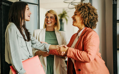 A group of three business women shaking hands