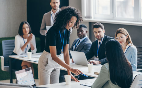 African American woman helps train a group of diverse men and women